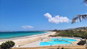 A beach resort with a swimming pool and a view of the ocean. - Beachfront Orient Bay 1‑BR Condo • Mont Vernon • Balcony • Pool • Fast Wi‑Fi (Cul de Sac)