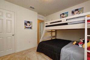 A bunk bed room with Mickey Mouse posters, a door, and a carpeted floor. - Lakefront Disney Retreat | Pet-Friendly | Family Fun in Compass Bay (Kissimmee)