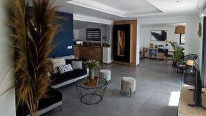 Ein geräumiger Wohnbereich mit einem modernen Sofa, einem Couchtisch und einem Essbereich mit Stühlen.