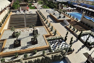 Un resort con piscina, mobiliario exterior y una zona a cuadros.