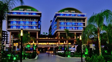 Un hotel moderno con dos edificios simétricos, cada uno con varios balcones y un atrio central.