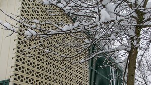 Un edificio con fachada ornamentada y entrada protegida por una reja.