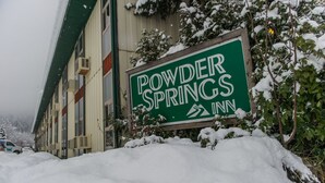 Señal del Powder Springs Inn con un paisaje nevado.