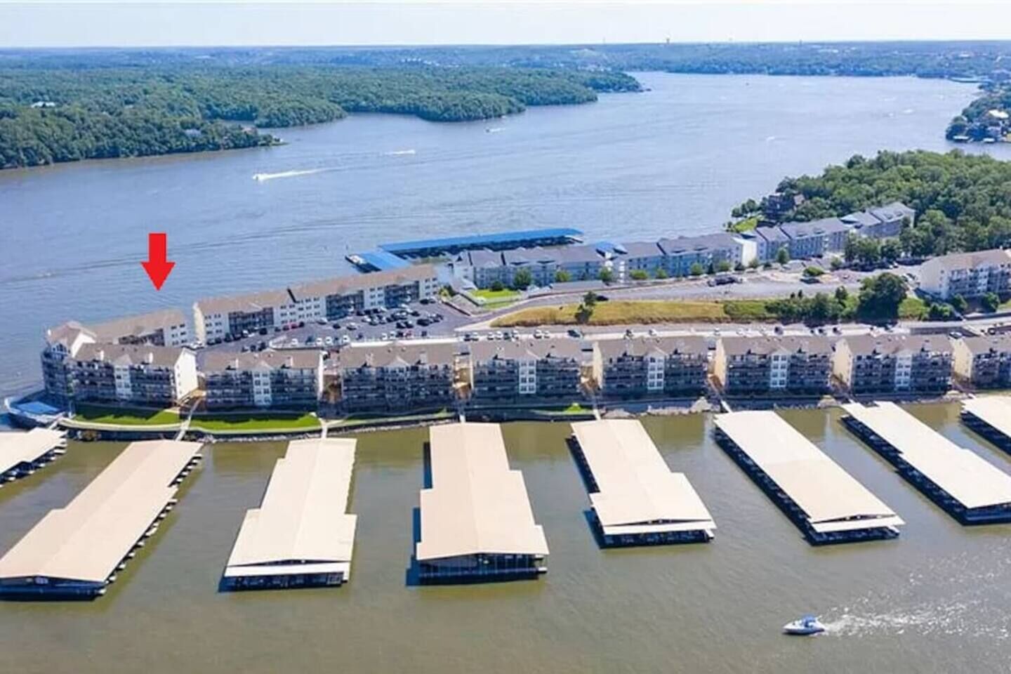 An aerial view of a waterfront residential area with multiple apartment buildings and a marina.