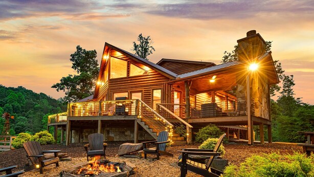 A log cabin with a deck, outdoor seating, and a fire pit. - Cherokee Vista - Pet Friendly | Mountain Views | Hot Tub | Shuffleboard | Fire Pit (Blue Ridge)