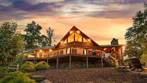 A wooden cabin with a balcony, surrounded by trees and a gravel path. - Cherokee Vista - Pet Friendly | Mountain Views | Hot Tub | Shuffleboard | Fire Pit (Blue Ridge)
