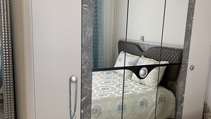 Una camera da letto con un letto, un armadio e uno specchio.