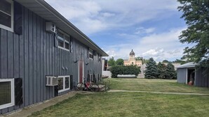 A building with a large lawn, a bicycle, and a distant building with a clock tower. - Wonderfully located two bedroom apartment (Pierre)