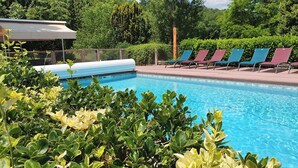 A swimming pool with lounge chairs and greenery. - A house of character (Puy-l'Évêque)