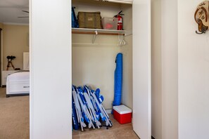 A room with a bed, a telescope, a fire extinguisher, and a storage area with a blue mat and a red cooler. - New Listing: Spacious 2-bedroom Luxurious Kapalua Golf Villa (Lahaina)