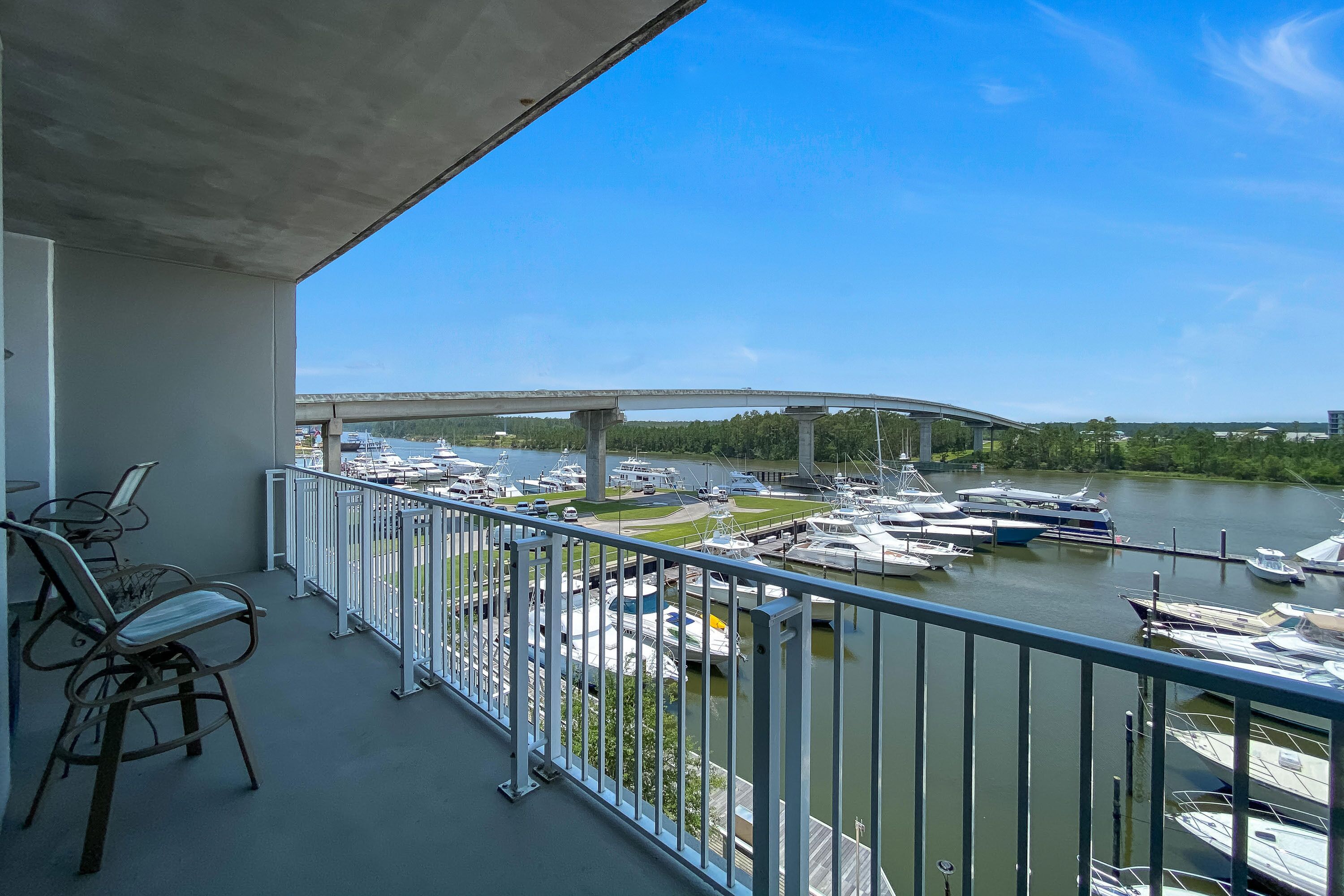 Un balcon avec vue sur un port de plaisance et un pont.