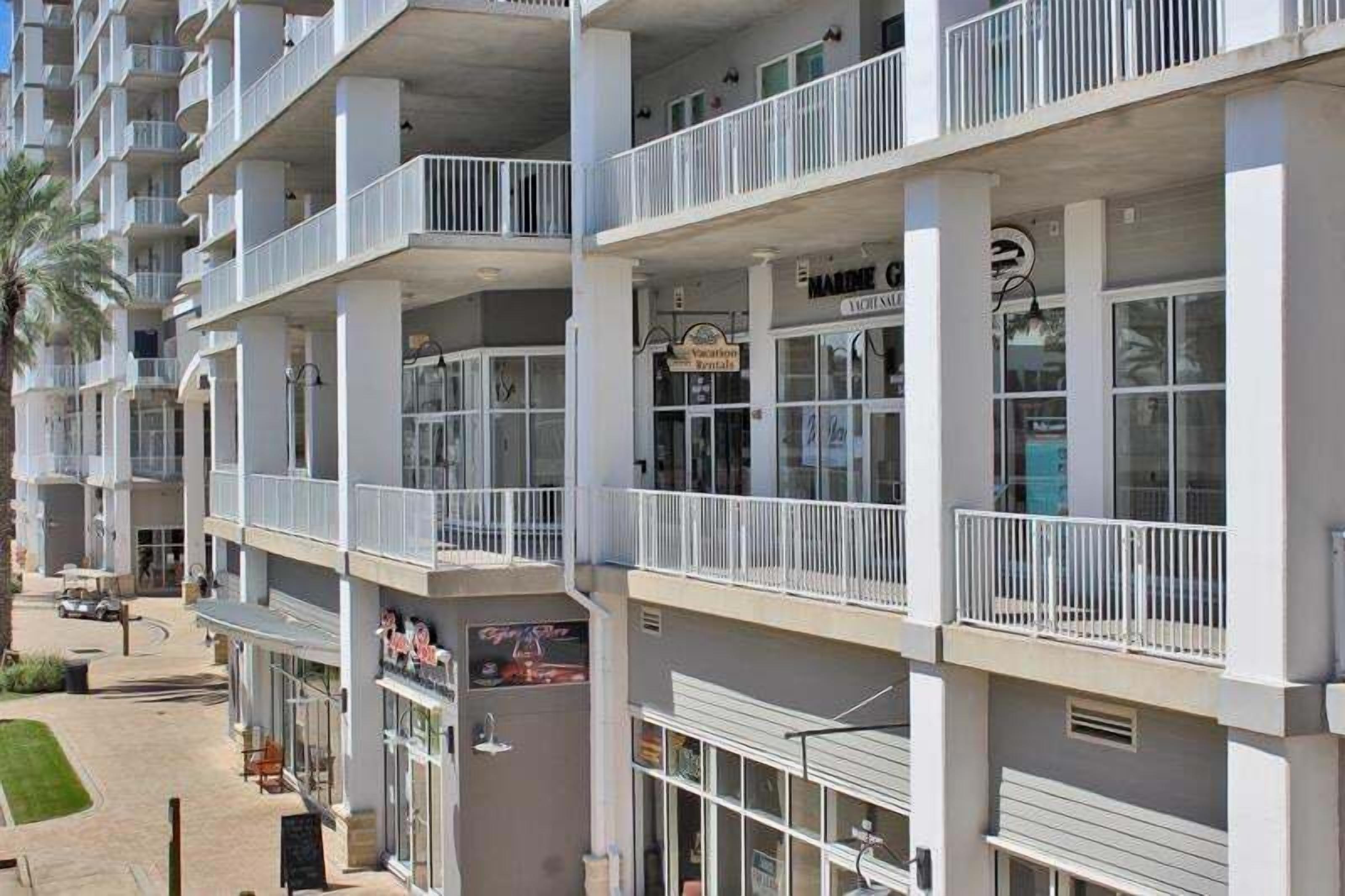 A multi-story hotel with balconies, a visible restaurant sign, and a parking area.