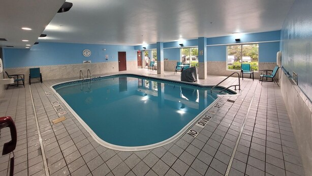 An indoor swimming pool with a tiled floor, a clock on the wall, and a no diving sign. - Comfort Inn & Suites Liverpool - Syracuse (Liverpool)