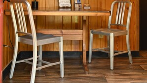 Una parete rivestita in legno con un cartello che recita “insieme” e un cartello di benvenuto. C'è un tavolo di legno con due sedie e una pianta in vaso.