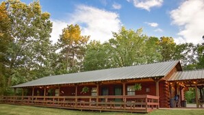 Een vakantiehuis van hout met een veranda en een overdekte picknickplaats.