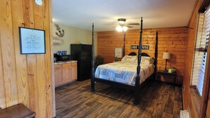 Een hemelbed met een 'Welcome' bord, een keuken met een koelkast, en een 'Lake House' bord aan de muur.