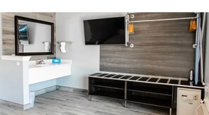 A modern bathroom with a large mirror, a flat-screen TV, a shower area, and a built-in bench. - Celebration Suites - 2 Miles from Disney - For 6 (Kissimmee)