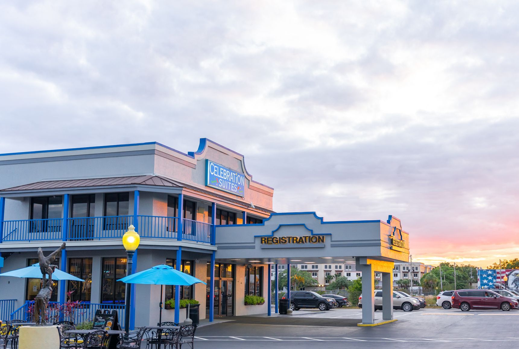 A family hotel with a registration area, outdoor seating, and a parking lot.