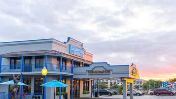 A family hotel with a registration area, outdoor seating, and a parking lot.