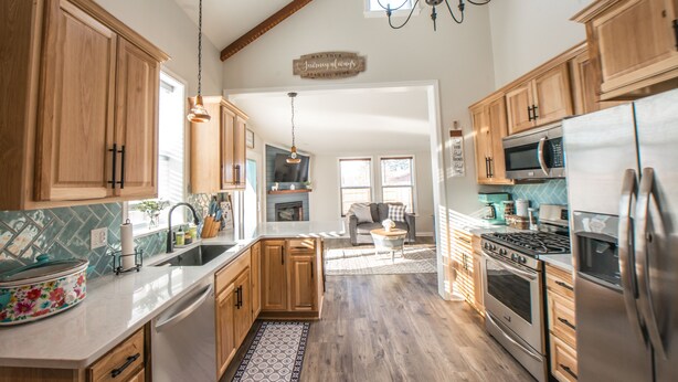 A spacious kitchen with wooden cabinets, stainless steel appliances, and a chandelier. - KING Master En-Suite- BRAND NEW Home- Buffalo's Best Kept Secret! (Buffalo)