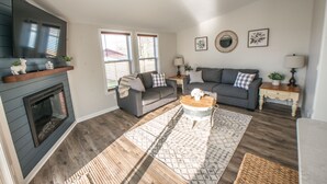 A living room with a fireplace, two sofas, a coffee table, and a rug. - KING Master En-Suite- BRAND NEW Home- Buffalo's Best Kept Secret! (Buffalo)