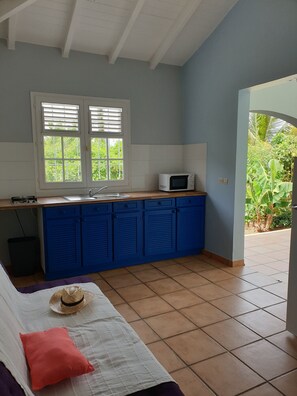 Mikrobølgeovn, kokeplater, kjøkkenutstyr og spisebord