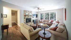 A living room with a fireplace, a sofa, a coffee table, and a TV.