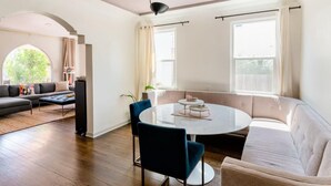 A modern living room with a round coffee table, two sofas, and a dining table.