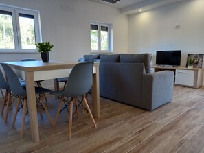 Relax in this stylish living space with a dining area, sofa, and flat-screen TV.