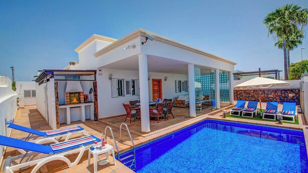 Un espace aménagé au bord de la piscine, comprenant une piscine, des chaises longues, un coin barbecue et une terrasse couverte.