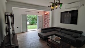 Uma sala de estar moderna com um sofá modular, uma mesa de centro de vidro e uma janela grande.