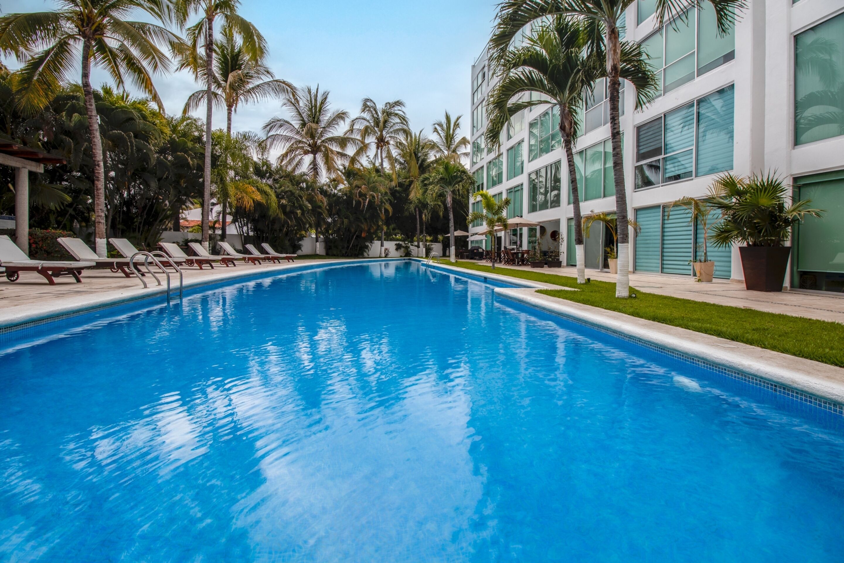 Alberca al aire libre, sombrillas en la alberca y camastros 