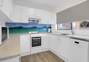 Enjoy cooking in this well-lit kitchen with a large island, stove, and oven.