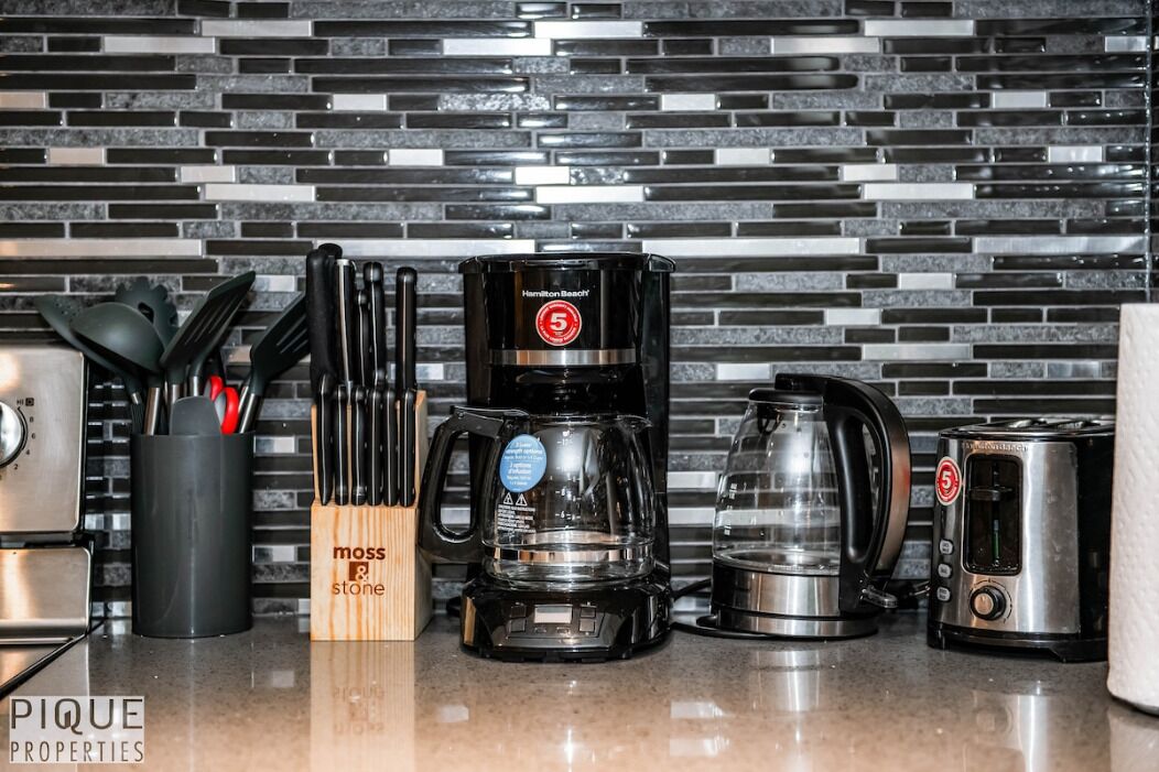 A kitchen with a Hamilton Beach coffee maker, a toaster, and a knife set in a wooden block.