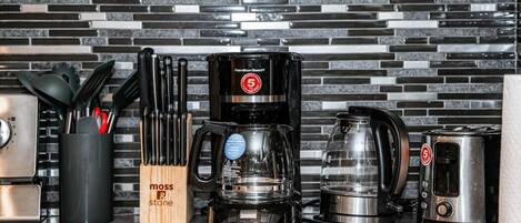 A kitchen with a Hamilton Beach coffee maker, a toaster, and a knife set in a wooden block.