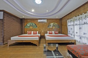 A hotel room with two beds, a small table, and a red sofa. - Blue Resort and Spa Koh Chang (Ko Chang)