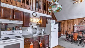 A kitchen with wooden cabinets, a stove, a sink, and a refrigerator. - Beautiful Red Chalet with  Hot-Tub and Sauna in Poconos (Long Pond)