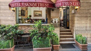 A hotel entrance with two large umbrellas, a reception desk, and potted plants. - Taksim Trust Hotel (Istanbul)