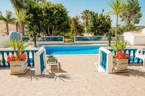 Relax by the rectangular pool surrounded by a geometric-patterned deck and lush greenery.