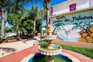 Surrounded by a serene garden, this tranquil oasis features a soothing water feature and a colorful mural-adorned building.