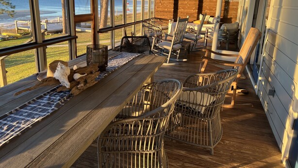 A wooden deck with wicker chairs and a long table, overlooking a beach and ocean. - The Best Beach-Front House “Get-A-Way” in Florida (Panacea)