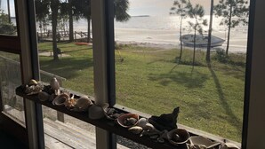 A view of a beach with palm trees and a boat in the distance. - The Best Beach-Front House “Get-A-Way” in Florida (Panacea)