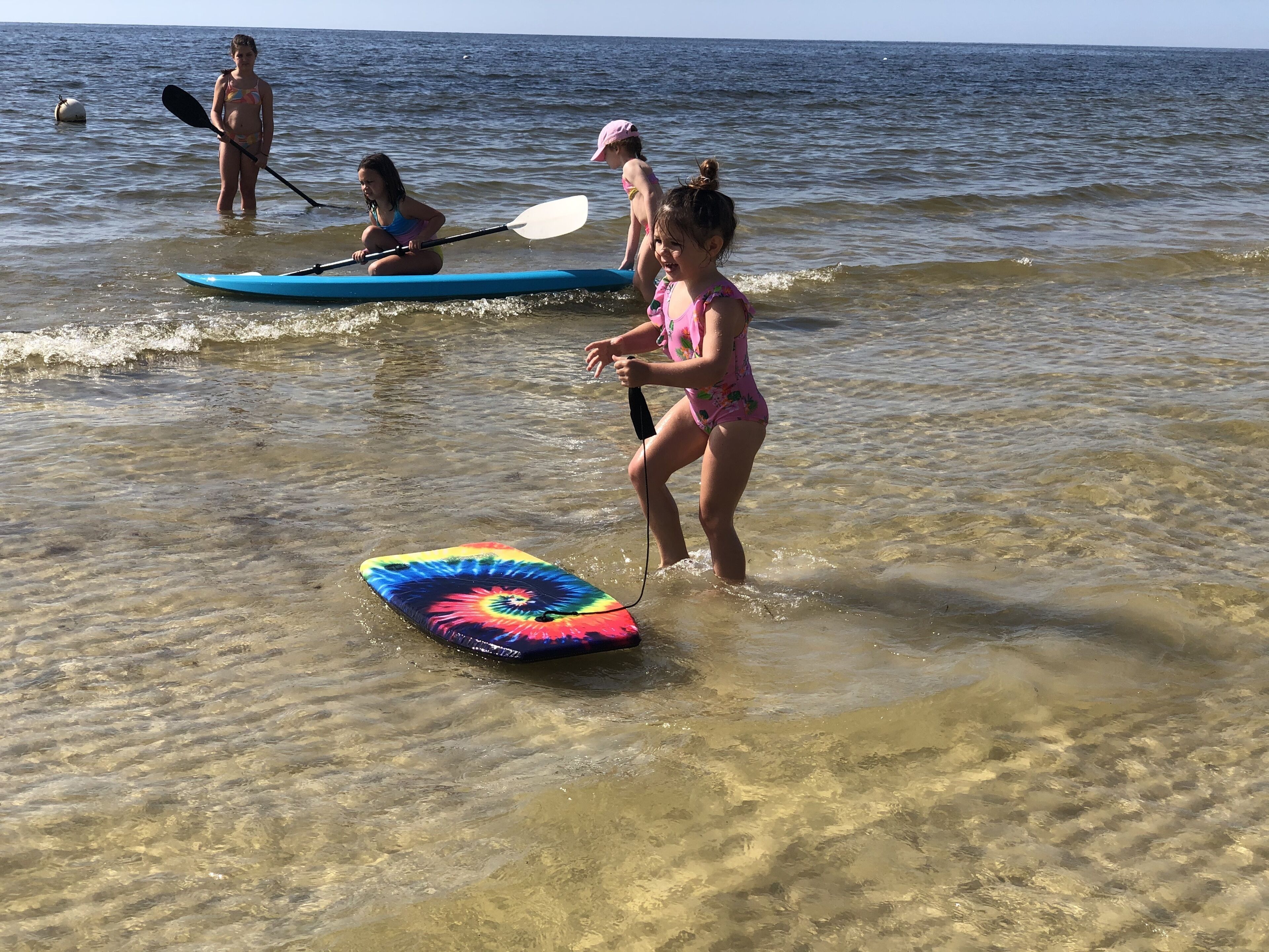Una spiaggia con persone che praticano attività acquatiche.