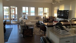 A spacious living room with a large TV, comfortable seating, and a view of the ocean through the windows. - The Best Beach-Front House “Get-A-Way” in Florida (Panacea)