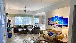 A spacious living room with a large sectional sofa, a coffee table, and a dining area in the background. - Mickey’s Vacation Villa-Premium- Minutes from Disney World with private pool! (Kissimmee)