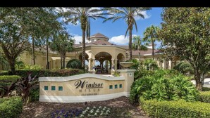 A sign for Windsor Hills Clubhouse surrounded by lush greenery and palm trees. - Mickey’s Vacation Villa-Premium- Minutes from Disney World with private pool! (Kissimmee)