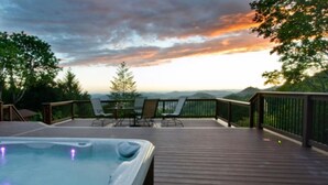 A wooden deck with a hot tub, outdoor seating, and a view of the mountains. - Views, good vibes, and vesper skies. (Calistoga)