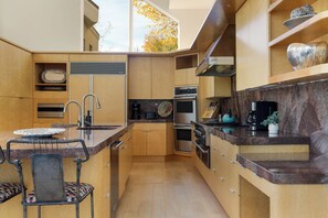 Una cocina moderna con armarios de madera, electrodomésticos de acero inoxidable y encimera de mármol.