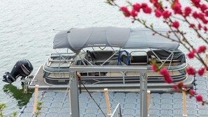 A pontoon boat with a covered seating area, a Mercury outboard motor, and a registration number. - Chuncheon El Dorado Kid's Pension (Chuncheon)