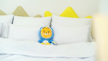 A bed with white bedding and a plush toy.